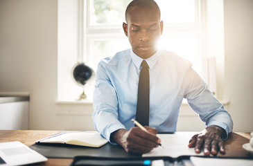 Young businessman signing contracts at his office desk