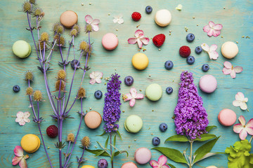 Obraz premium Variety of colorful french sweet dessert - les macarons with flowers and berries.