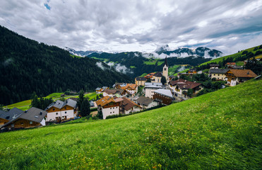 Fototapeta na wymiar View of the Alpine village La Valle (La Val) in Dolomites. Trentino Alto Adidge, Italy.