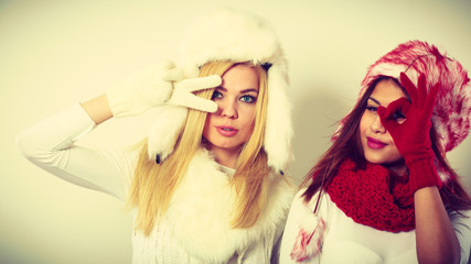 Two girls warm winter clothing having fun.