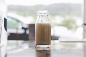 Open very small vintage retro glass bottle of milk with milk inside