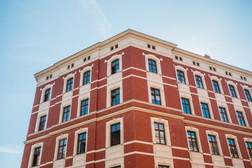 Fototapeta na wymiar beautiful brick corner building with red facade and clean sky