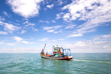 Obraz premium Fishing boat on a sea and deep bluesky background,Thailand 