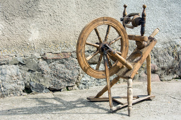 Beautiful old spinning wheel standing against a wall - horizontal photo