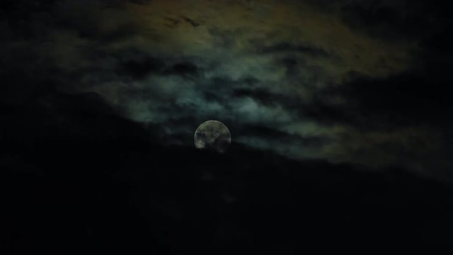 New moon and clouds in the pitchblack sky. Long shot