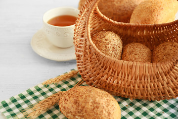 Beautiful composition with wicker basket and delicious bread on wooden table