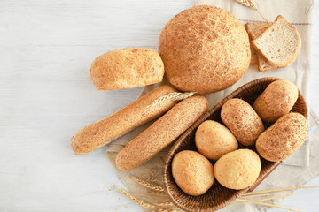 Beautiful composition with wicker basket and delicious bread on wooden table