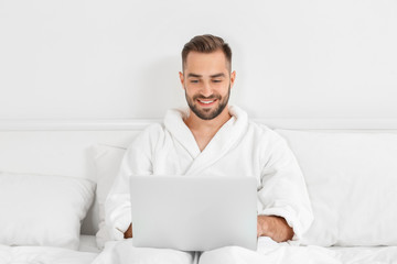 Young man using laptop in hotel room