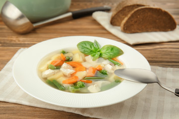 Plate with delicious turkey soup on table