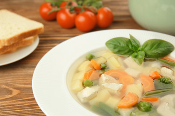 Plate with delicious turkey soup on table, closeup