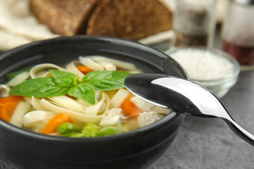 Bowl with delicious turkey soup on table, closeup
