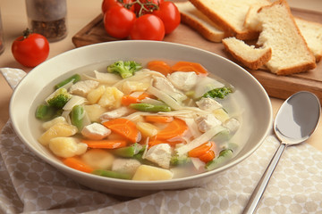 Plate with delicious turkey soup on table