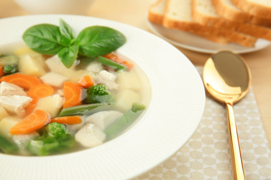 Plate with delicious turkey soup on table, closeup