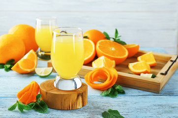 Wooden stand with glass of orange juice on table