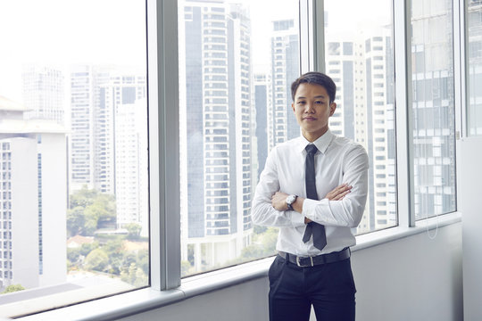 Portrait of a young Chinese banker with arms folded