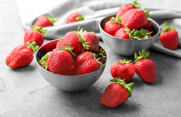 Bowl with delicious strawberry on grey table