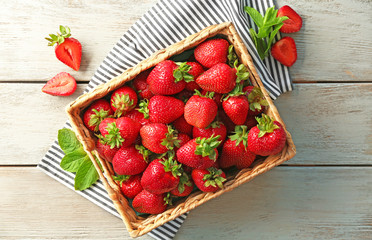 Wicker box with delicious fresh strawberry on wooden table