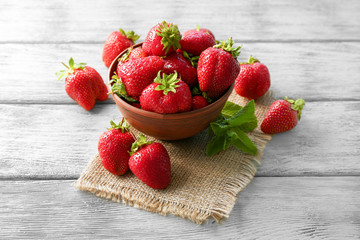 Bowl with delicious fresh strawberry on wooden table