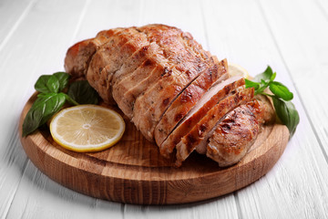 Cutting board with delicious sliced turkey fillet on table