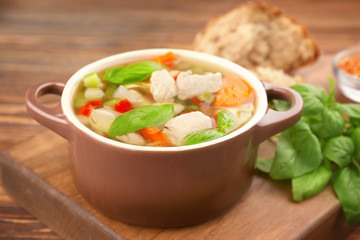 Casserole with delicious turkey soup on table