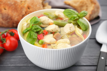 Bowl with delicious turkey soup on wooden table, closeup
