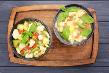 Two bowls with delicious turkey soup on table