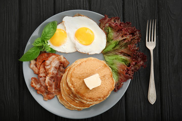 Tasty breakfast with fried eggs, pancakes and bacon on plate