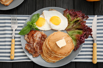 Tasty breakfast with fried eggs, pancakes and bacon on plate