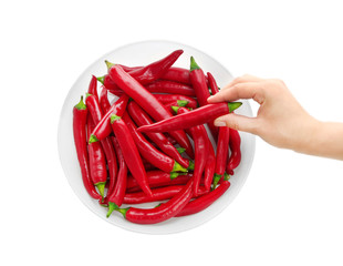 Woman's hand taking red chili pepper out of bowl isolated on white