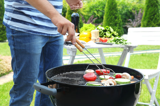 Man cooking vegetables on barbecue grill