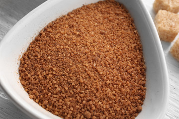 Cinnamon sugar in white bowl on wooden background, closeup
