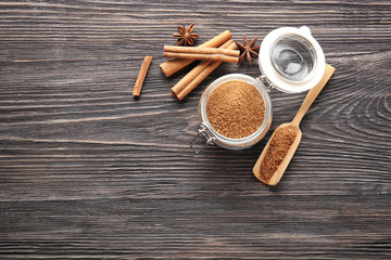 Composition with cinnamon sugar in jar and scoop on wooden background