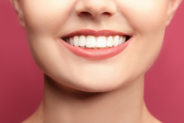 Obraz premium Young woman with healthy teeth on colour background, closeup