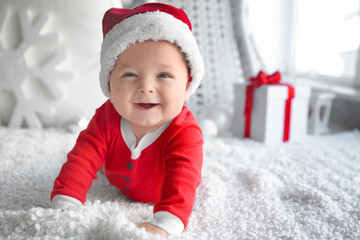 Cute little baby in Santa hat on soft fabric