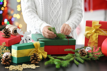 Woman wrapping gift for Christmas at table
