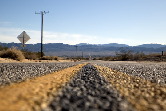 Empty asphalt road through a desert in California, USA	