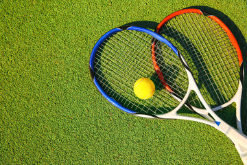 Tennis ball and rackets on court