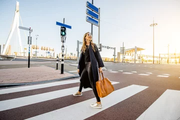 Cercles muraux Rotterdam Femme d& 39 affaires élégante traversant la rue dans le quartier moderne le matin dans la ville de Rotterdam