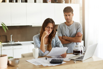 Candid shot of young American man and woman dressed casually feeling stressed while managing...