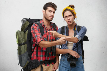 It's totally your fault. Picture of angry male and female hikers or tourists equipped with...