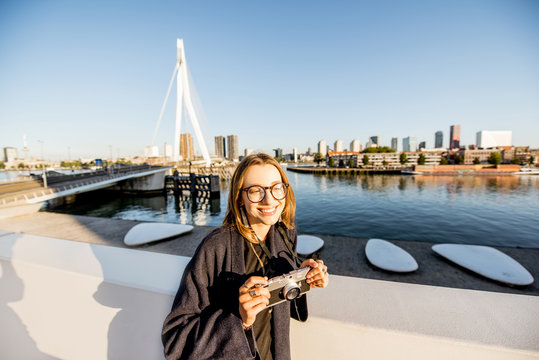Portrait of a young woman tourist standing on the beautiful morning cityscape background in Rotterdam city