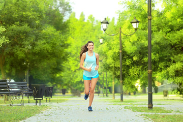 Morning of young sporty woman running in park