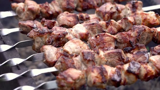 Grilling pork kebab on skewers at bbq, cooking process