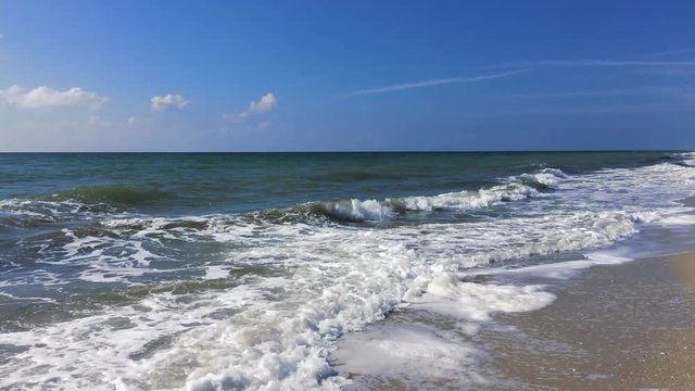 view from the shore to the Black Sea with waves, blue clear sky