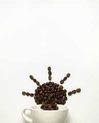 Morning in your cup / Creative valentine concept photo of cup with the sun made of coffee beans on white background.