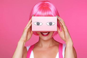 femme sexy avec perruque rose regardant dans une boîte de réalité virtuelle