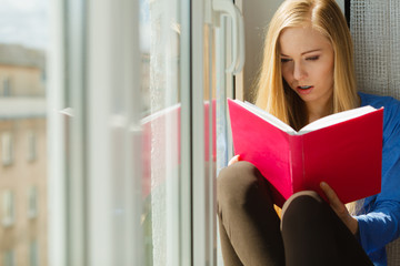 Woman reading on windowsill
