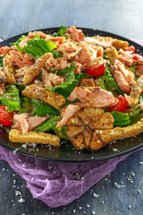 Cesar salad with salmon, cherry tomatoes, garlic, crutons, romaine lettuce and parmesan.