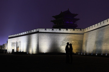 Silhouette of a couple kissing in front of the walls of Pingyao (UNESCO World Heritage site). A...