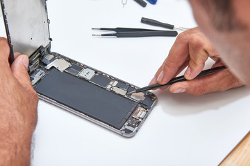 Technician Hand Repairing Cellphone,process of mobile phone repair, isolated on white background,Selective focus